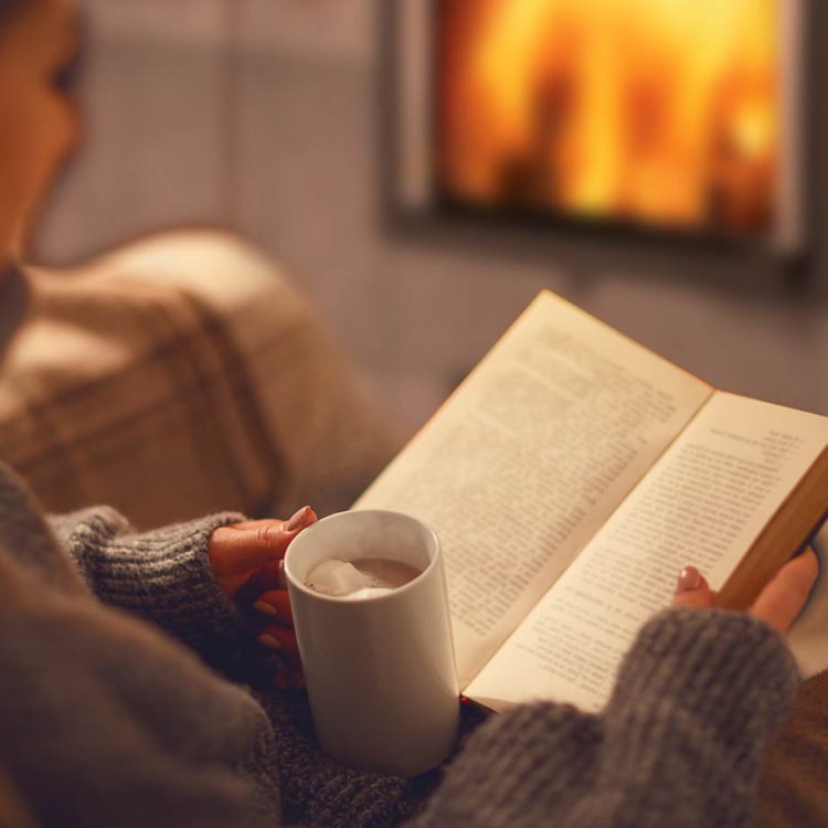 Fireplace, woman, hot chocolate and book